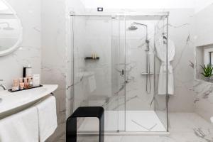 a bathroom with a shower with a black stool at Hotel La Ville Rome in Rome