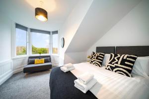 a bedroom with a bed and a chair and a window at The Crossroads in Elderslie