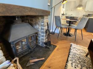 uma sala de estar com lareira, mesa e cadeiras em Cosy 2 bedroom cottage in Scarborough's Old Town em Scarborough
