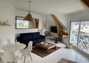 een woonkamer met een blauwe bank en een tafel bij Superbe appartement 4 personnes Le Pouliguen avec vue magnifique sur le port et la mer in Le Pouliguen