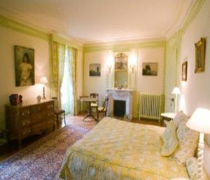 a large bedroom with a bed and a fireplace at Château de Sarceaux in Alençon