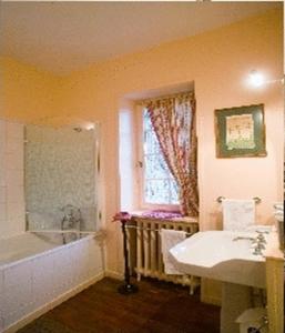 a bathroom with a sink and a tub and a window at Château de Sarceaux in Alençon