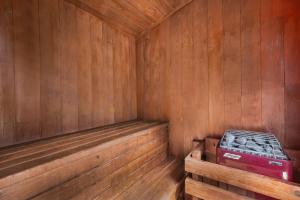 a wooden sauna with a bench and a red box at Timbers Motel in Bigfork