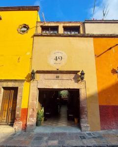 a building with a yellow and orange building with a tunnel at Hotel Mesones 49 in San Miguel de Allende