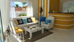 a living room with a couch and chairs and a table at Estrela Azul Guest House Búzios in Búzios