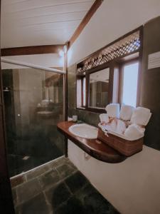 a bathroom with a sink and a mirror at Pousada Vento Sul - Arraial D'Ajuda in Arraial d'Ajuda