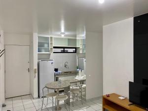 een keuken met een tafel en stoelen en een koelkast bij Perto da Praia e Piscina na cobertura in Maceió