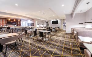 a dining room with tables and chairs at Holiday Inn Hotel & Suites - Orange Park - Wells Rd. in Orange Park