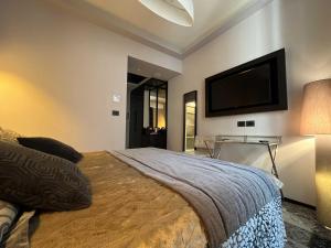 a bedroom with a bed and a flat screen tv at Flâneur - Rooms & Suites by Visconti in Rome