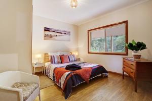 - une chambre avec un lit, une fenêtre et une chaise dans l'établissement Farm Stay & Iconic Water Views - 32 Zachary Drive, à Mallacoota
