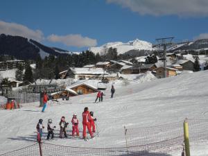 a group of people skiing down a snow covered slope at Appartement REINE DES PRES in Megève