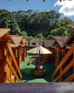 einen Blick über einen Spielplatz mit Sonnenschirm und Stühlen in der Unterkunft Pousada Recanto Viva a Vida in Domingos Martins