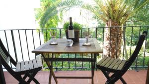 a table with a bottle of wine and two chairs at Clip B-2 - Llafranc in Llafranc
