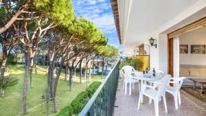 een balkon met een tafel, stoelen en bomen bij CV - Calella de Palafrugell in Calella de Palafrugell