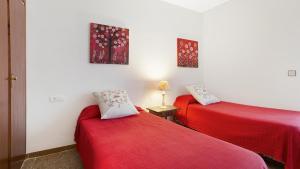 twee bedden in een kamer met rode lakens bij CV - Calella de Palafrugell in Calella de Palafrugell
