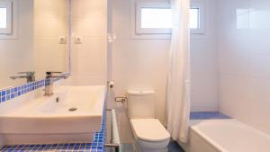 een witte badkamer met een toilet en een wastafel bij CV - Calella de Palafrugell in Calella de Palafrugell +33 foto's