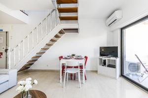 un soggiorno bianco con tavolo e scala di Guia Alamos Duplex Apartment a Cascais