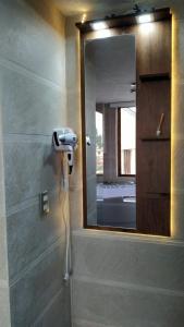 a bathroom with a mirror and a hair dryer at Hotel Casa Sakiwa in Machachi