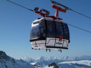 a cable car flying over a snow covered mountain at The little refuge of La Plagne (French Alps) in Plagne 1800