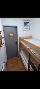 a room with a door and a bunk bed at The little refuge of La Plagne (French Alps) in Plagne 1800