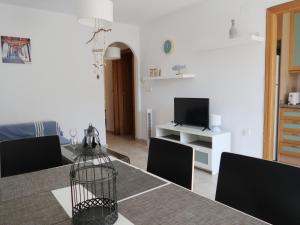 een woonkamer met een tafel met stoelen en een televisie bij Emilia de la Playa in La Mata