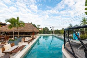 een zwembad in een resort met tafels en stoelen bij Mayan Monkey Tulum in Tulum