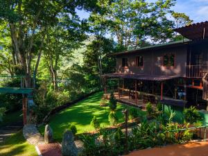 an exterior view of a house with a green yard at Hotel de Montaña El Pelicano in San Isidro de El General