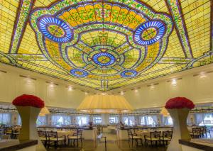 a large room with tables and a stained glass ceiling at Moon Palace Cancun - All Inclusive in Cancún