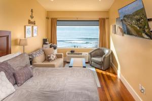 Sala de estar con cama y vistas al océano en Three Arch Inn, en Oceanside