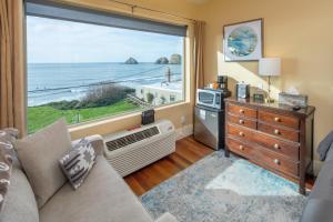 een woonkamer met een groot raam met uitzicht op de oceaan bij Three Arch Inn in Oceanside