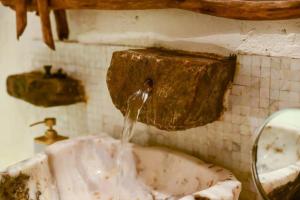a dirty bathroom with a sink with water coming out at Ella Retreat Hotel Villa for Nature Lovers in Ella