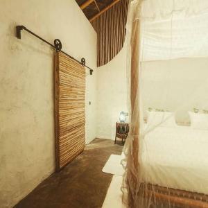 1 dormitorio con 1 cama y puerta de madera en Ella Retreat Cottage for Nature Lovers, en Ella