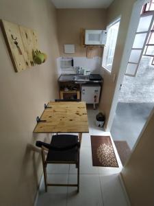una pequeña cocina con mesa de madera y sillas en Container LB PONU, en Boa Vista