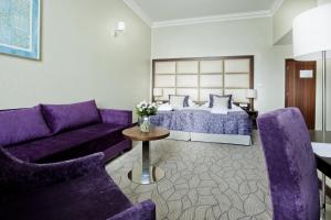 a hotel room with a purple bed and a couch at Kosher Hotel King David Prague in Prague