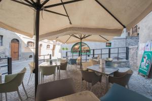 a restaurant with tables and chairs and umbrellas at Albergo Al Tempo Perduto in Bagolino