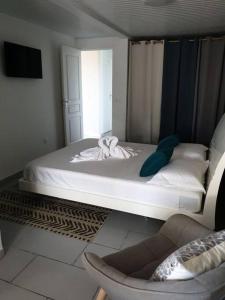 um quarto com uma cama com uma cadeira e uma janela em MARS ET VENUS LOCATION - piscine privée et chauffée em Sainte-Marie