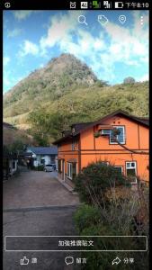 ein orangefarbenes Gebäude mit einem Berg im Hintergrund in der Unterkunft Natural Residence B&B in Taian