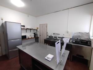 a kitchen with a counter and a refrigerator at Keimichi Guest House in Hakuba