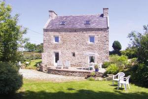 a stone house with white chairs in front of it at Granite stone house with fireplace, Plouguerneau in Plouguerneau