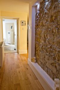 a room with a stone wall and a hallway at Heritage City - Central New Town Apartment in Edinburgh