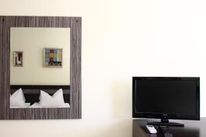 a mirror in a hotel room with a tv at Vila Raluca in Eforie Nord