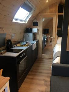 a kitchen with a sink and a stove in a room at Owls Retreat Glamping Pod with Hot tub in Keith