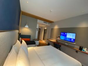 上海市にあるHoliday Inn Express Shanghai Tangzhen, an IHG Hotelのベッド1台、薄型テレビが備わるホテルルームです。