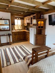 eine Küche mit Holzschränken und einem Kühlschrank in der Unterkunft Cabańas de La Ochi in Niebla