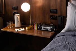 a bedroom with a table with a radio and a bed at The Intrepid Hotel in Wellington