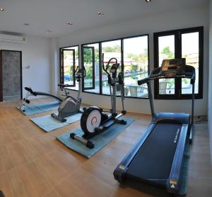 a gym with several treadmills and elliptical machines at Poonyamantra Resort in Ban Rai
