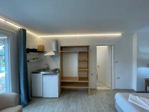 una pequeña cocina con fregadero y una habitación con cama en Syros village suites, en Vári