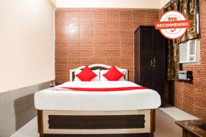 Bett mit roten Kissen in einem Zimmer in der Unterkunft Flagship Hotel Embassy Exhibition Rd in Patna