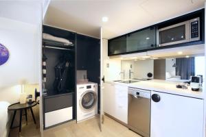 a kitchen with a washing machine and a washer at Miss Baker's Boutique Accommodation Bondi in Sydney