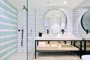 a bathroom with two sinks and a mirror at Miss Baker's Boutique Accommodation Bondi in Sydney